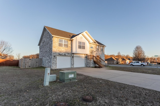 view of front of property featuring a garage, driveway, and fence