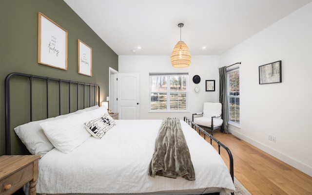 bedroom with baseboards, wood finished floors, and recessed lighting