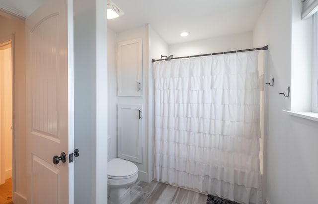 bathroom with toilet and a shower with shower curtain