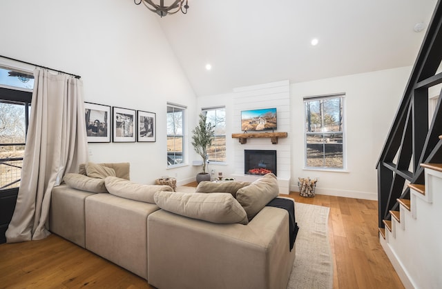 living area featuring high vaulted ceiling, plenty of natural light, and a fireplace