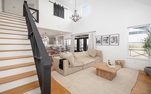 living room with recessed lighting, light wood-style flooring, an inviting chandelier, baseboards, and stairs