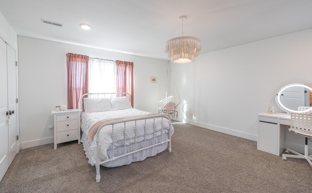 carpeted bedroom featuring baseboards, visible vents, and a notable chandelier