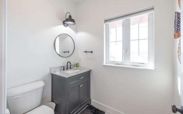 bathroom with vanity, toilet, and baseboards