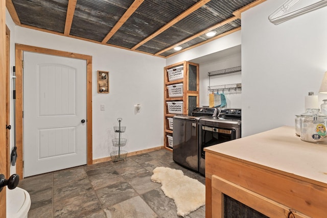 interior space featuring stone finish flooring, separate washer and dryer, and baseboards