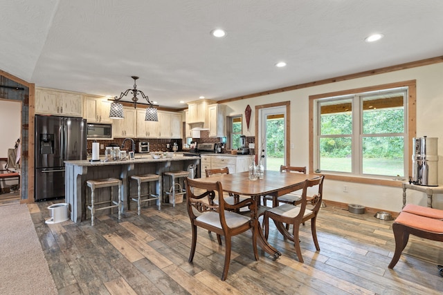 dining room with crown molding, baseboards, dark wood-style flooring, and recessed lighting