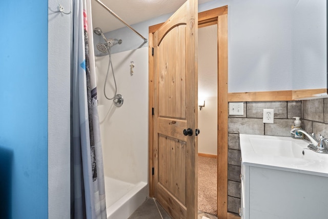 bathroom featuring a shower stall and vanity