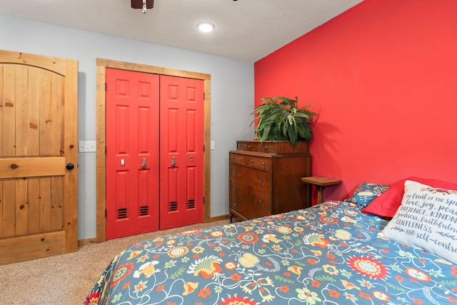 bedroom featuring a textured ceiling, ceiling fan, a closet, and carpet