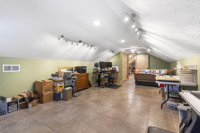 interior space featuring lofted ceiling, a textured ceiling, and visible vents