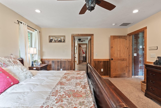 bedroom with recessed lighting, a wainscoted wall, visible vents, and wood walls