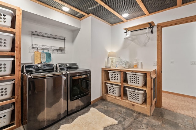 laundry room featuring stone finish floor, laundry area, independent washer and dryer, and baseboards