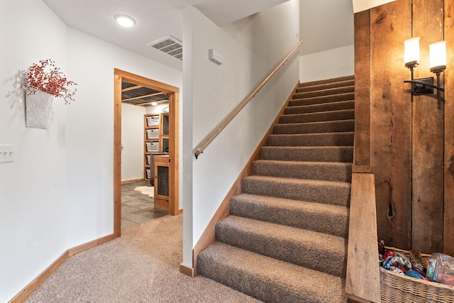 stairway featuring carpet, visible vents, and baseboards