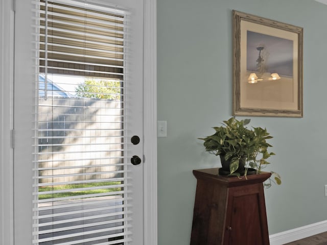 doorway to outside featuring baseboards