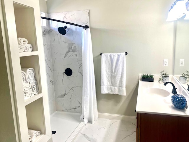 full bath featuring a stall shower, marble finish floor, vanity, and baseboards