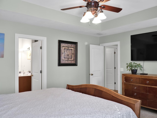 bedroom with ensuite bath, ceiling fan, visible vents, and a sink