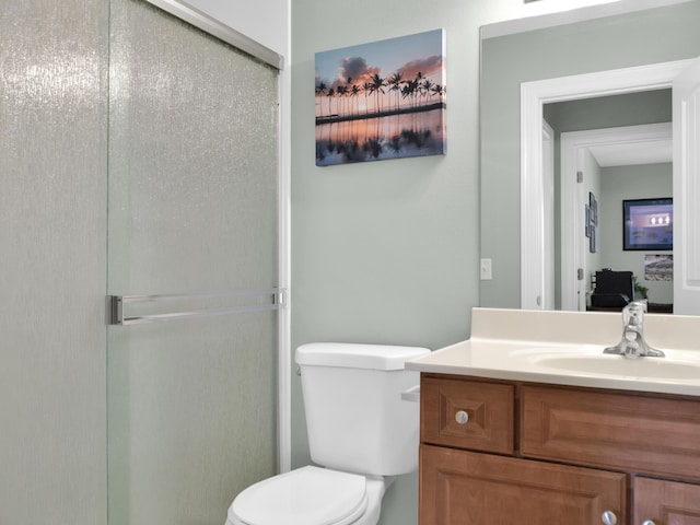 bathroom with toilet, a stall shower, and vanity