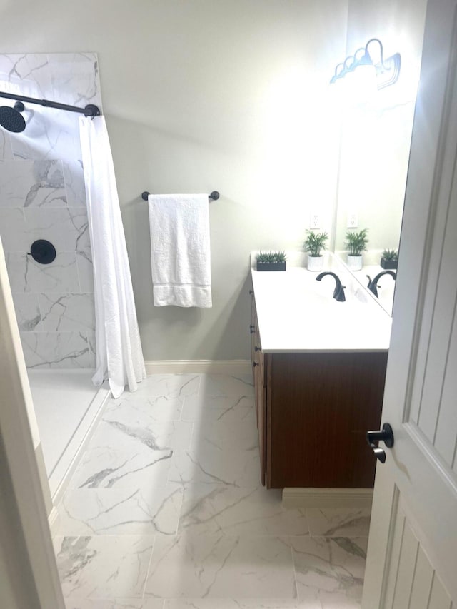 bathroom with a stall shower, marble finish floor, vanity, and baseboards