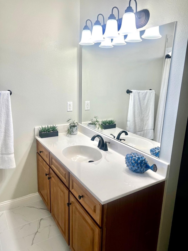 bathroom featuring marble finish floor, baseboards, and vanity