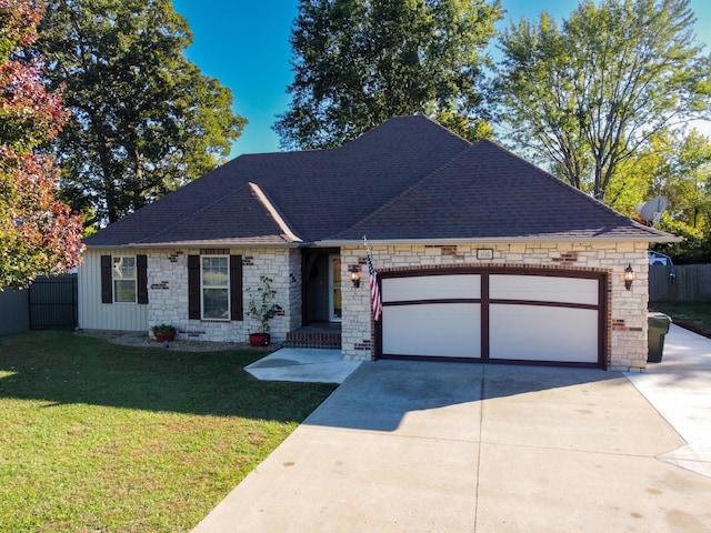 view of front facade with a front lawn, concrete driveway, fence, and an attached garage