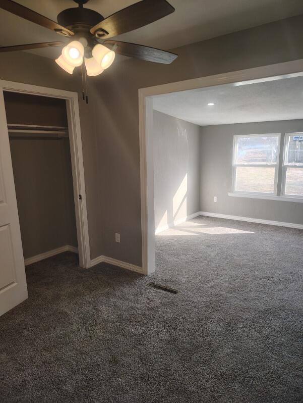 unfurnished bedroom with carpet floors, visible vents, and baseboards