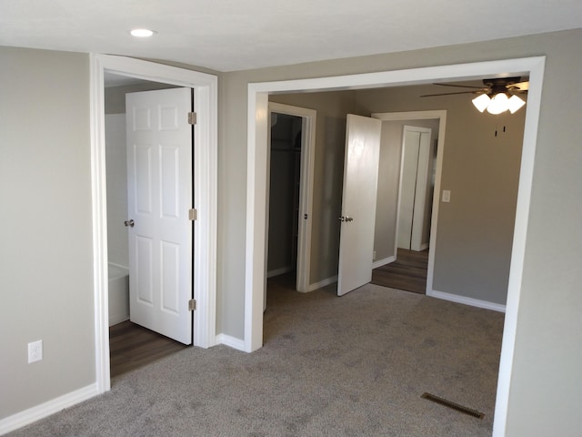 empty room with carpet, visible vents, and baseboards