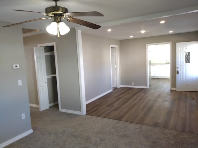 carpeted spare room featuring a ceiling fan, recessed lighting, baseboards, and wood finished floors