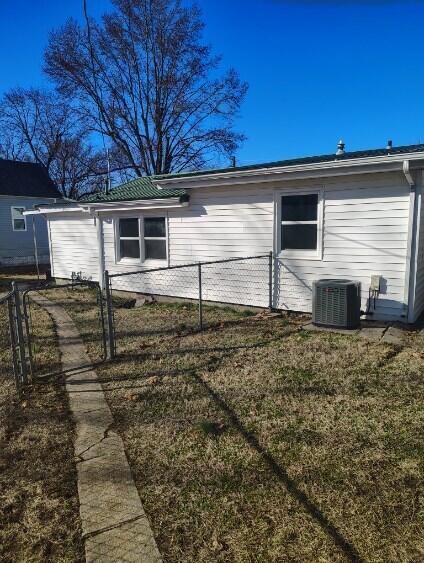 view of side of home featuring cooling unit, a gate, and fence