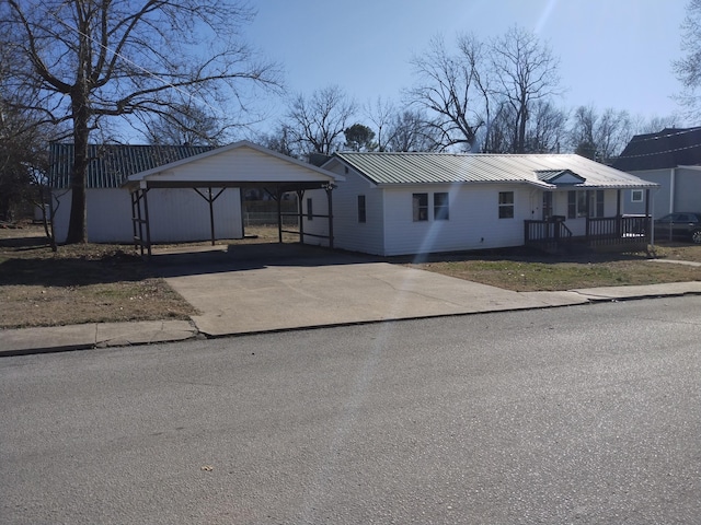 view of front of house featuring a carport, metal roof, and aphalt driveway