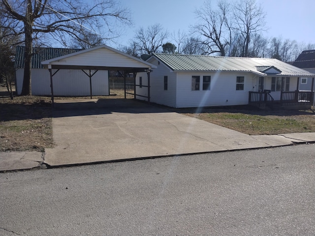 view of front of house with metal roof, a carport, and aphalt driveway