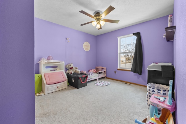 bedroom with a textured ceiling, carpet floors, a ceiling fan, visible vents, and baseboards