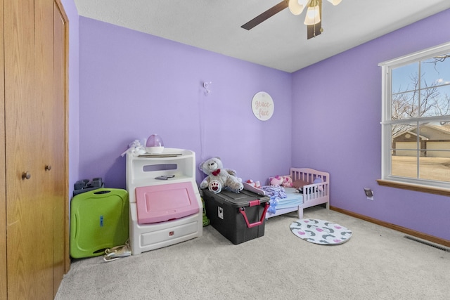 carpeted bedroom featuring a ceiling fan, visible vents, and baseboards