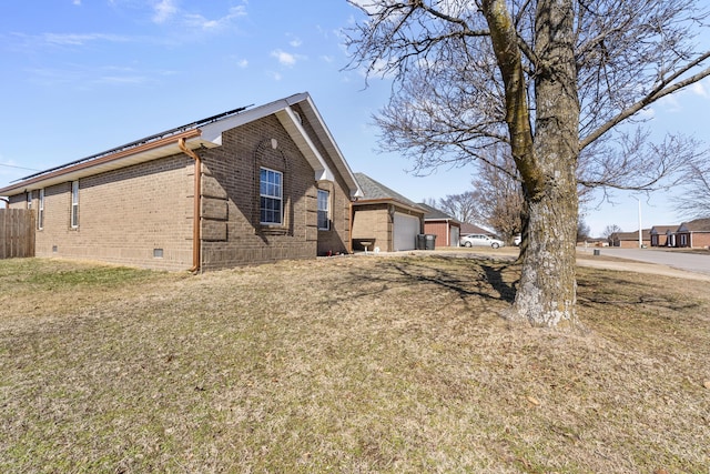 view of property exterior with a garage, solar panels, crawl space, fence, and brick siding