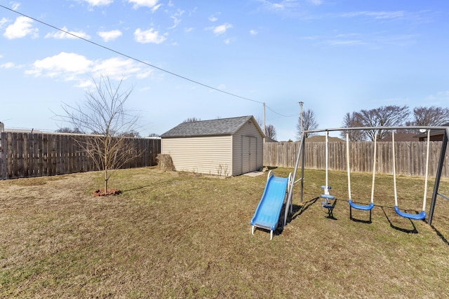 view of yard with a playground, a storage unit, an outdoor structure, and a fenced backyard