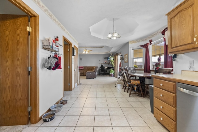 kitchen with light tile patterned floors, open floor plan, an inviting chandelier, light countertops, and stainless steel dishwasher