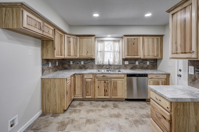 kitchen with a sink, backsplash, and stainless steel dishwasher