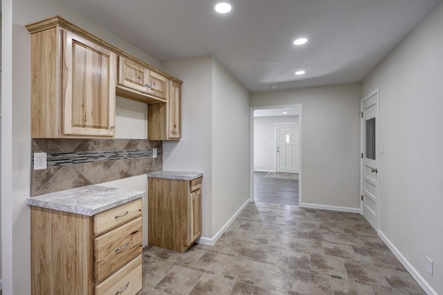 kitchen featuring light countertops, recessed lighting, backsplash, and baseboards