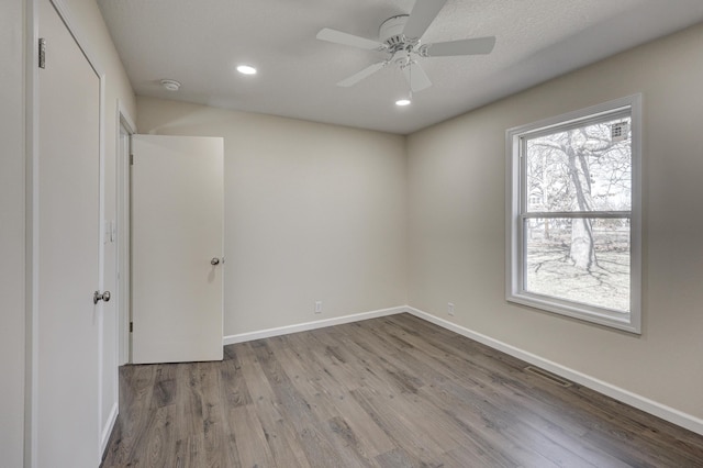 unfurnished bedroom with ceiling fan, recessed lighting, wood finished floors, visible vents, and baseboards