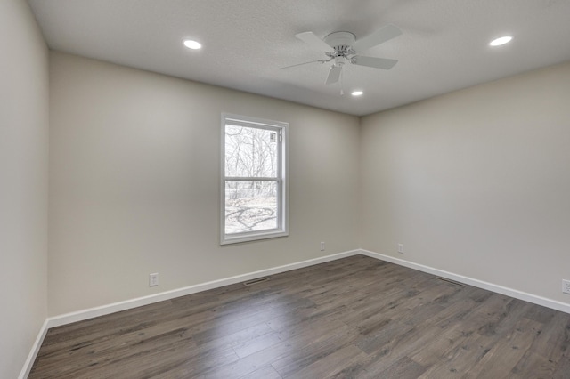 empty room with dark wood-style floors, recessed lighting, and baseboards