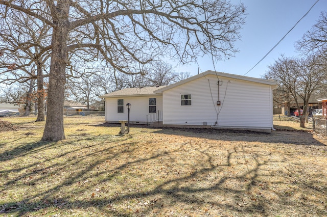 rear view of property with a yard and fence