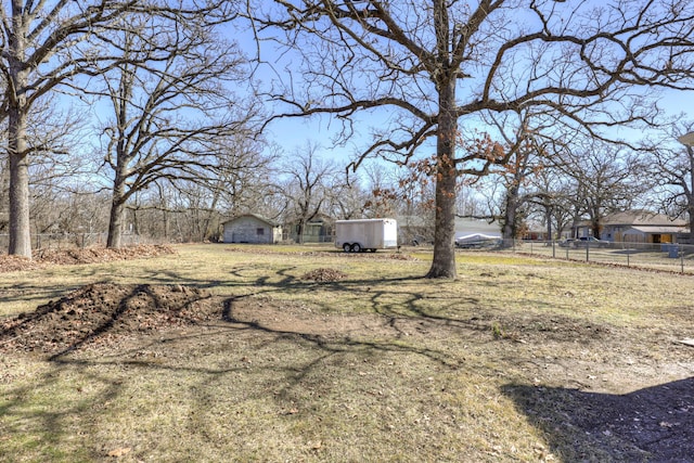 view of yard with fence and an outbuilding