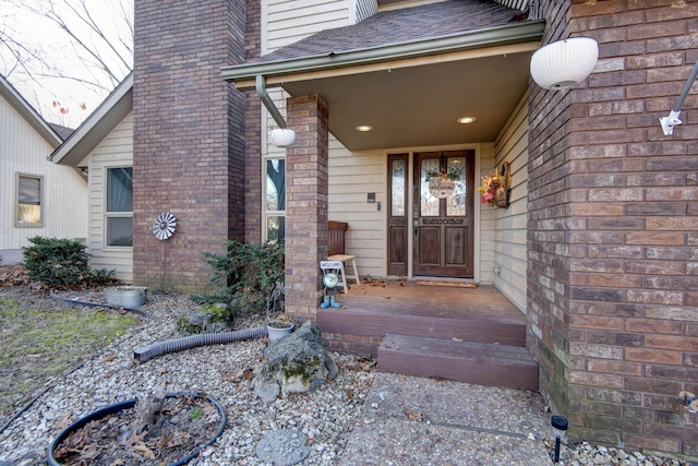 property entrance featuring a shingled roof and a chimney