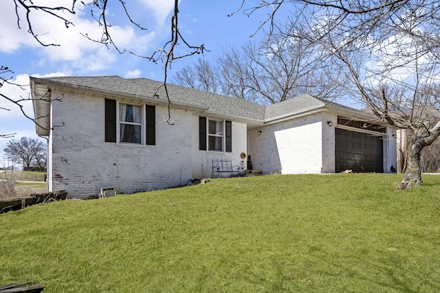 ranch-style house with an attached garage, roof with shingles, a front lawn, and brick siding