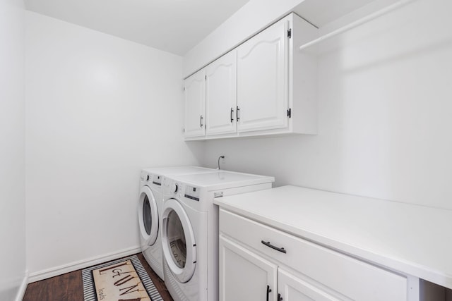 laundry room featuring baseboards, cabinet space, washing machine and clothes dryer, and wood finished floors