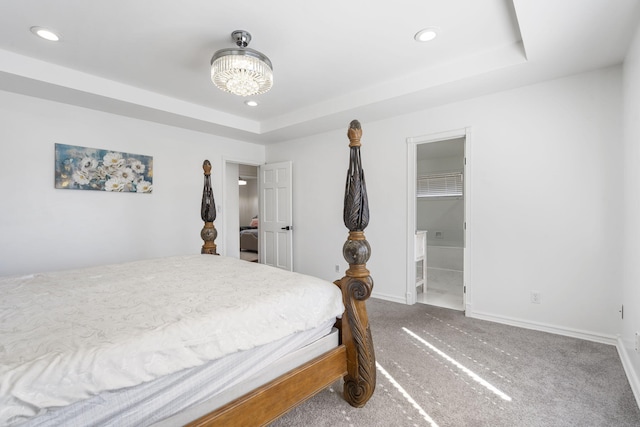 bedroom with baseboards, ensuite bath, a tray ceiling, carpet floors, and recessed lighting