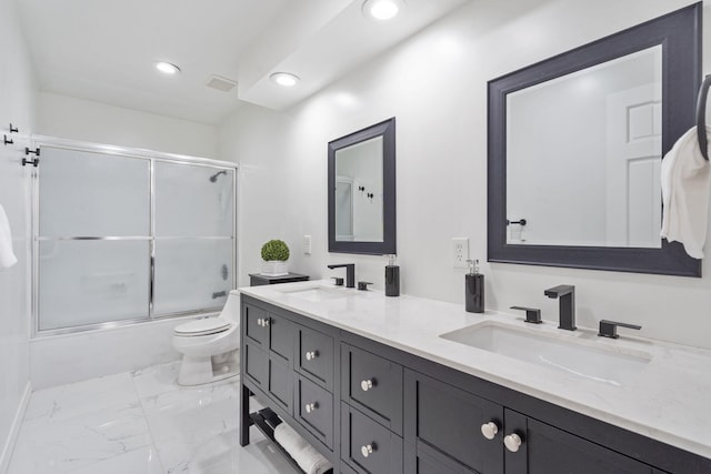 bathroom featuring enclosed tub / shower combo, marble finish floor, a sink, and toilet