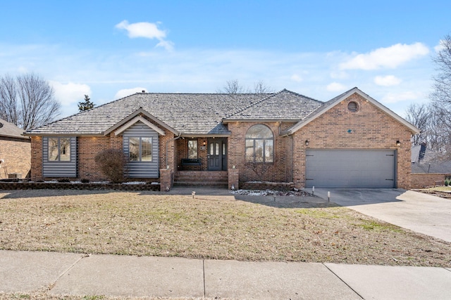 single story home featuring a garage, a front lawn, concrete driveway, and brick siding