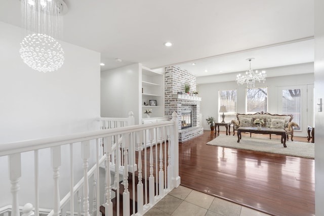 hall with an upstairs landing, tile patterned flooring, a notable chandelier, and recessed lighting