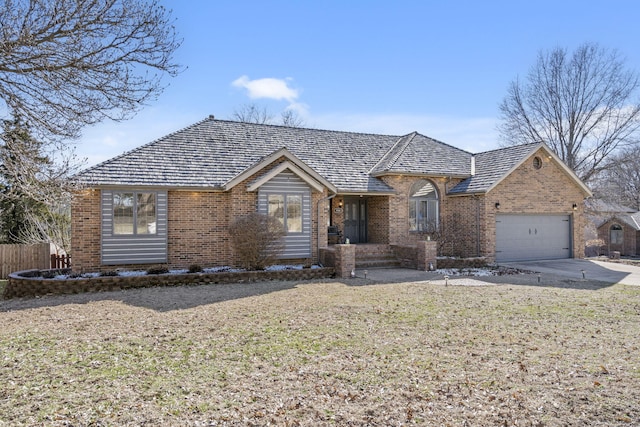 ranch-style home with a garage, a front yard, concrete driveway, and brick siding