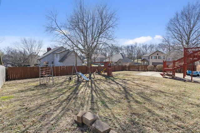 view of yard with a patio area, a playground, and a fenced backyard