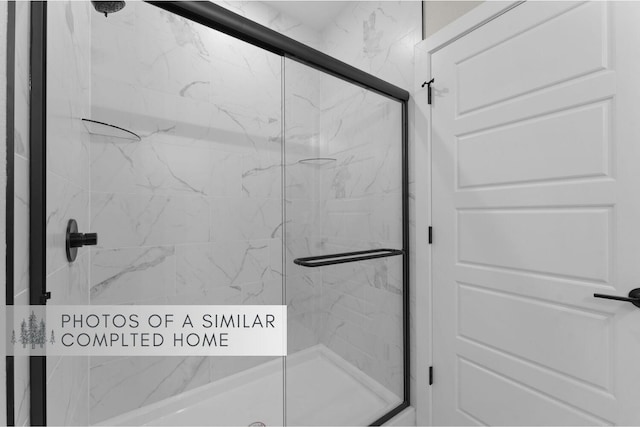 bathroom featuring a marble finish shower