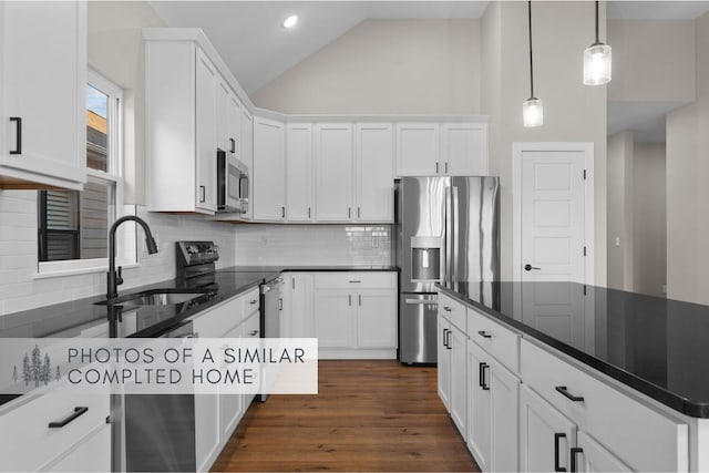 kitchen with appliances with stainless steel finishes, dark wood-type flooring, a sink, and white cabinetry